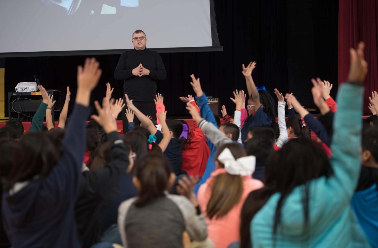 Children watch a host and pianist at a Cliburn in the Classroom program