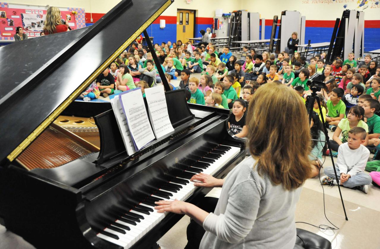 Children watch a host and pianist at a Cliburn in the Classroom program
