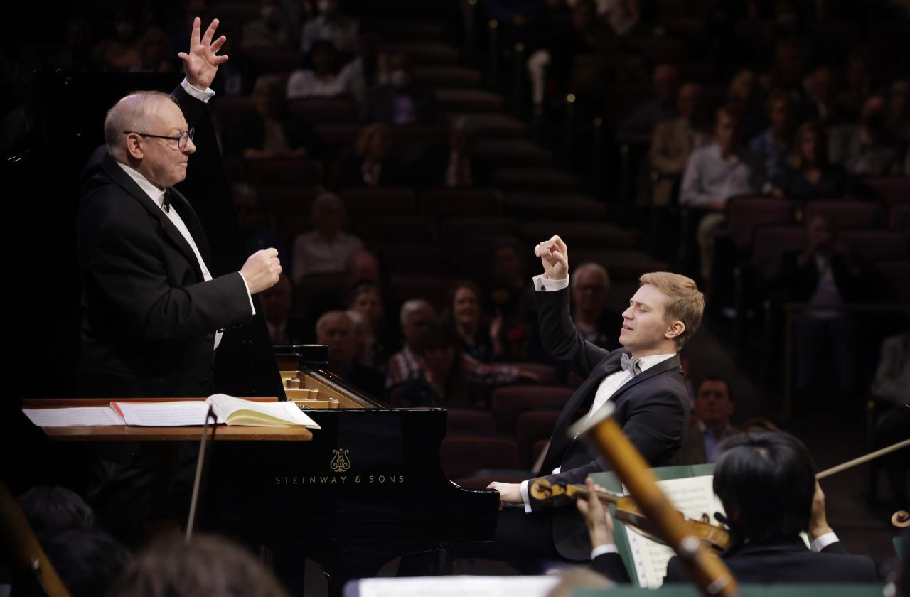 Dmytro Choni and the conductor performing each with an arm in the air